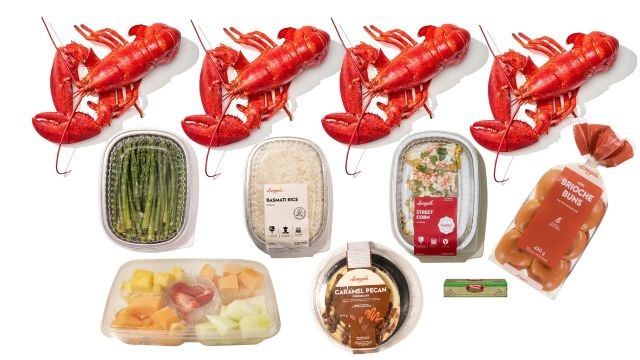 Lobster dinner catering spread with four whole lobsters, asparagus, sauces, and sides, perfect for celebrations and events.